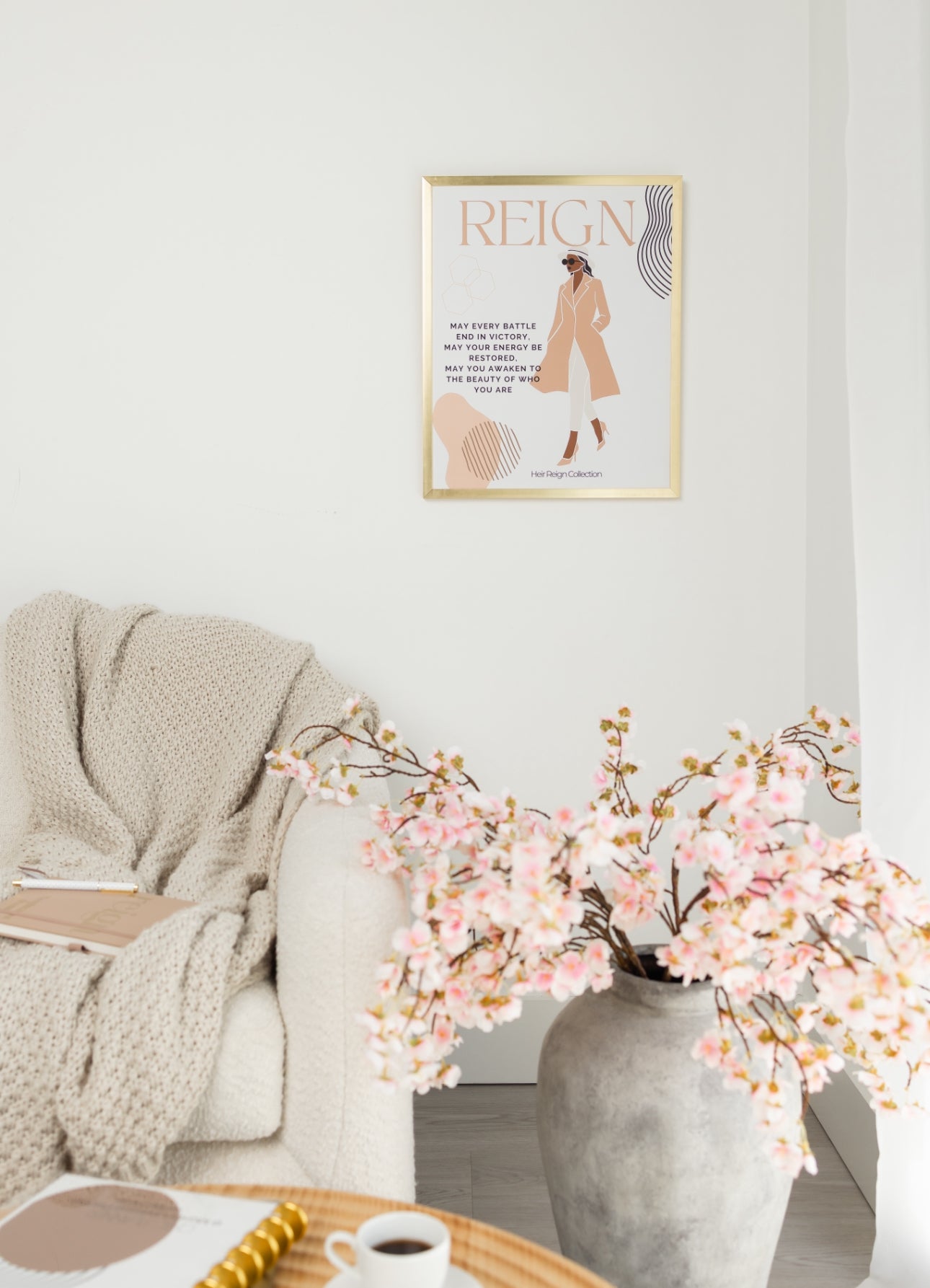 Beautiful wall art illustration of a black woman. She is wearing a pink trench coat, white  pants and high heel shoes. The picture also has an inspirational positive affirmation next to the woman. The picture is in a  gold frame with beautiful home decor. 