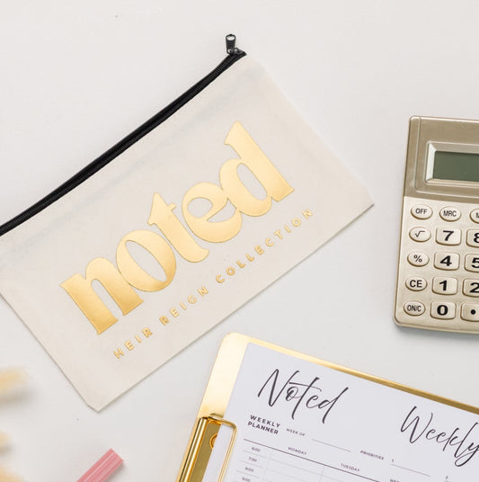 Weekly planner on a desk with pens, calculator, and notebook.